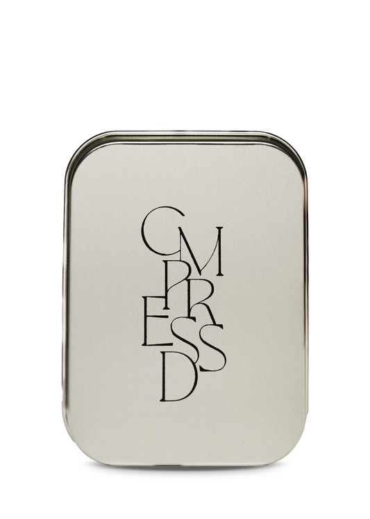 Silver travel tin with 'CMPRESSD' text on a white background